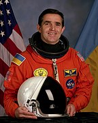 Leonid Kadenyuk at NASA; note different shades of blue on the patch and on the flag behind (1997)