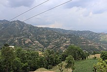 The green farmland of Ravi village wit Anekot on the backdrop