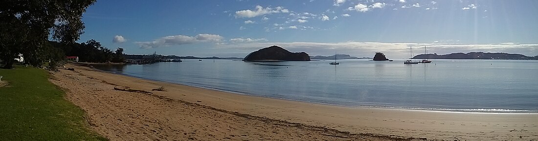 Panorama of Taiputuputu Pahi Beach looking north towards Paihia Wharf and Motumarie