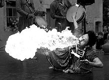 A grayscale image showing the HSV value component of the photograph leaves the flame completely white (in photographer's parlance, "blown out"), and the man's clothing much too bright.