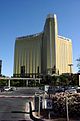 Ground-level view of a building with three thin towers that meet at a central point to form a Y-shape; each has a golden glass facade.