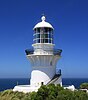 A white lighthouse with a gallery, a lantern and an external stairway