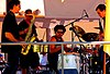 A modern salsa band lineup including less traditional salsa instruments such as a saxophone and a full drumset.