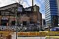 View of Carrer Pallars in Poblenou, showing renovation of underground infrastructure, as well as one of many former factories next to a modern building.