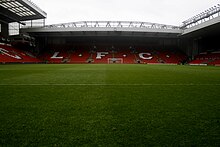 A stand of a football stadium. The seats are red and the words "LFC" are written in white seats.