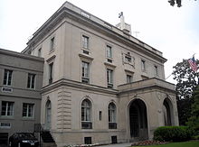 An three story gray mansion, with an impressive covered front entrance