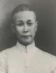 A black-and-white photograph of Zhang Jingsheng looking forward. He is a middle-aged Chinese man wearing a light collar shirt.