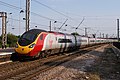 In standard livery, 11 car, shows a whole unit, but part of the unit is obscured by fencing/OHLE and the light is a little uneven.