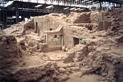 Excavation into rock showing doors and windows among the rubble.