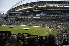 A view of a soccer field from high in the crowd before a match.