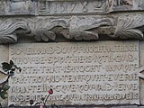 Inscription plaque below coats of arms set into one of the towers