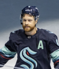 Hockey player in a blue Seattle Kraken hockey jersey.