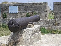 19th-century cannon, set in the wall of Acre near a sign commemorating Farhi. The Hebrew inscription on the sign reads: Farhi vs. Napoleon. Jezzar's right hand in resisting Napoleon's harsh siege was the Jewish Haim Farhi, senior adviser and minister of finance