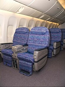 The interior of Biman's Boeing 777 aircraft showing the fronts of seats which are light blue in colour.