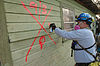 Rescue worker marking a house for number of bodies, for later recovery by coroner.