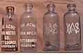 Acme Soda Water Company bottles with paint applied on the embossing