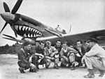 Pilots of No. 457 Squadron receive final instructions at the airstrip for their flight back to Australia in October 1945.