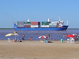 Container ship, traveling downstream by the city of Ramallo, Argentina