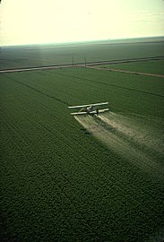 A cropduster spraying pesticide on a field