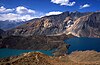 Picture of the Usoi Dam holding back two lakes at slightly different levels in a mountainous landscape