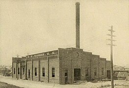 A one-story brick powerhouse with a chimney