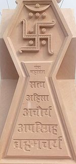 Tan stone relief of the Jain swastika and its five vows