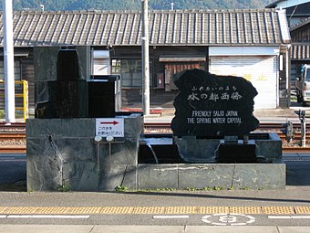 A fountain serving water from a natural spring on the island platform. The white sign says: "Please drink".