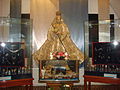 A replica in the image's veneration chapel behind the main altar. The glass cases contain the original image's regalia, perfumes, and scale models of the galleons it travelled on.