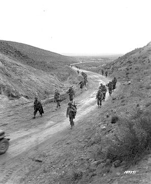 The 2nd Battalion, 16th Infantry marching through the Kasserine Pass