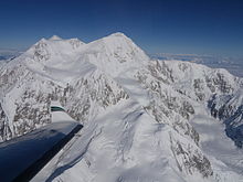 An aerial view of Mount McKinley. An airplane wing is visible in the lower-left corner.