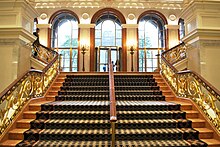 View of the Palace Hotel's lobby, formerly the center wing of the Villard Houses. A staircase leads up to a set of three arches that formed the entrances to 453 and 455 Madison Avenue.