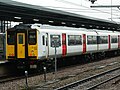 317345 at Cambridge in black-stripe with red doors livery.