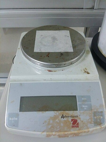 File:Weighing paper on balance.jpg