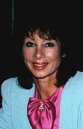 A 45-year-old woman with dark hair smiling at the camera.