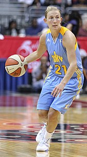 woman in light blue uniform dribbling the ball