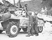 M8 armored car on patrol from U.S. 11th Armored Division, U.S. Third Army links up with soldiers of the U.S. 84th Infantry Division of U.S. First Army west of Houffalize, Belgium. 16 January 1945.