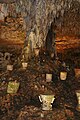 Photo of the great limestone column in the Cave of Balankanche, surrounded by Tlaloc-themed incense burners