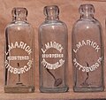 Louis Marick bottles with paint applied on the embossing