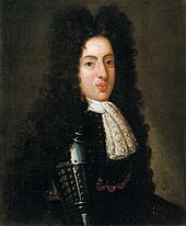 A 19-year-old man wears a black suit of armour and peri-wig.