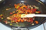 Caramelizing onions, with carrots and celery. Frying oil can easily rise above boiling point, and food left in it for long enough to dry out can char (for instance, caramelized onions are slightly charred). Putting a lid on the frying pan keeps the water in, and some of it re-condenses, keeping the temperature lower for longer.