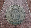 Coat of arms at sister city Celle (Germany), granite artwork below signpost