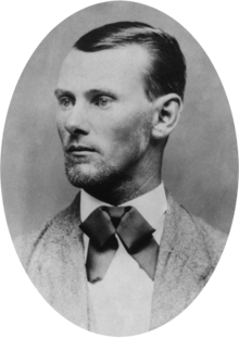 Oval-shaped black-and-white portrait photograph of a man with short slicked-back hair