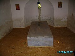 Photo of a plain marble tomb with a cross inside a small room