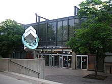 a low steel and glass building and concrete courtyard, with the words Paul V. Galvin Library about a bank of doors, flanked by trees and an abstract steel sculpture