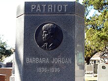 Barbara Jordan's gravestone at the Texas State Cemetery in Austin, Texas. Picture is of Jordan's gravestone which includes the word "patriot" carved at the top followed by an engraving of Jordan's profile.