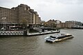 A Thames Clipper catamaran passes the pier (Tower Hotel in the background)