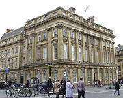 Bank building on corner of street; faced with yellow stone and pilasters