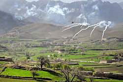 A U.S. Apache shooting flares over a valley in the Daykundi Province in April 2012.