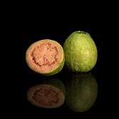 A photo of a pink guava on a black background