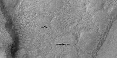 Brain terrain is forming from the breakdown of upper plains unit, as seen by HiRISE under HiWish program. Arrow points to a place where fractures are forming that will turn into brain terrain.